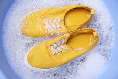Washing sport shoes in plastic basin, top view