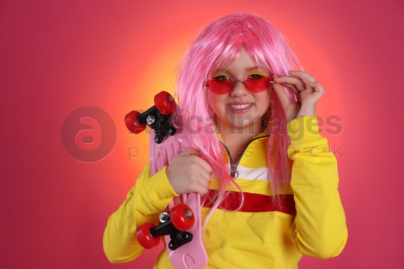 Cute indie girl with sunglasses and penny board on bright pink background, space for text