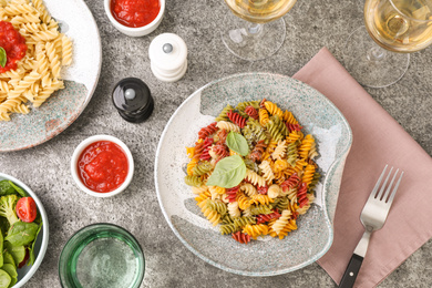 Flat lay composition with tasty pasta on grey table