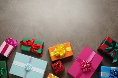 Many colorful gift boxes on grey table, flat lay. Space for text