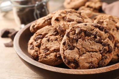 Photo of Plate with delicious chocolate chip cookies on wooden table, closeup