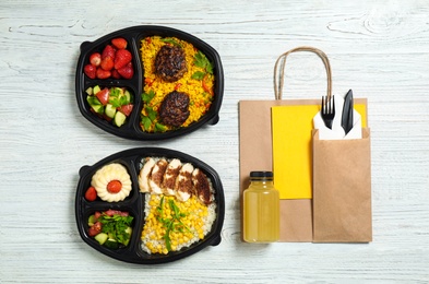 Flat lay composition with lunchboxes on white wooden table. Healthy food delivery