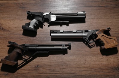 Different pistols on wooden table. Gun shooting sport