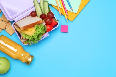 Lunchbox with tasty food, juice and school stationery on light blue background, flat lay. Space for text