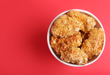 Photo of Bucket with yummy nuggets on pink background, top view. Space for text