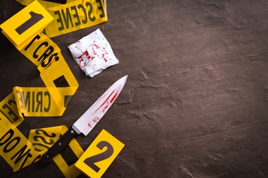 Flat lay composition with evidences on black slate background, space for text. Crime scene
