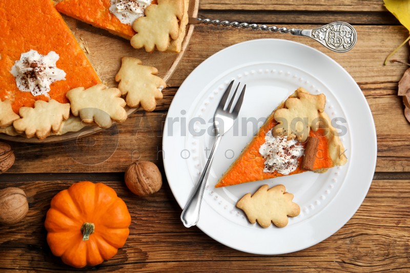 Delicious homemade pumpkin pie on wooden table, flat lay