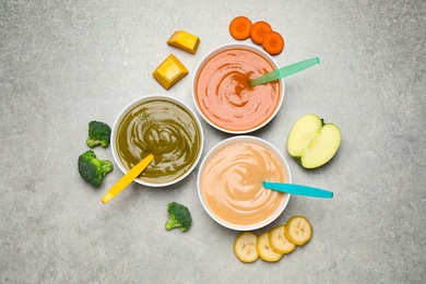 Healthy baby food and ingredients on grey table, flat lay