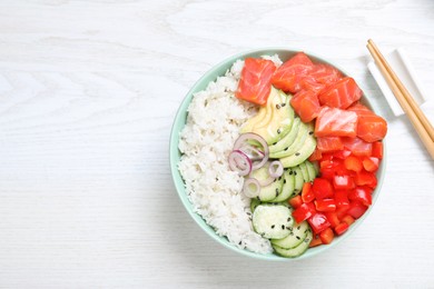 Delicious poke bowl with salmon and vegetables served on white wooden table, flat lay. Space for text