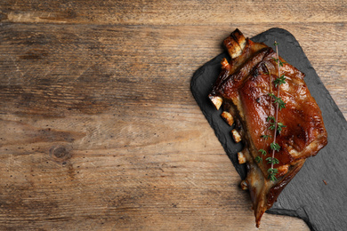 Photo of Delicious roasted ribs served on wooden table, top view. Space for text