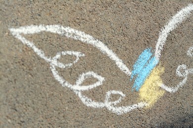 Angel drawn with colorful chalks on asphalt outdoors, closeup