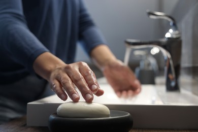 Photo of Woman taking soap to wash hands in bathroom, closeup