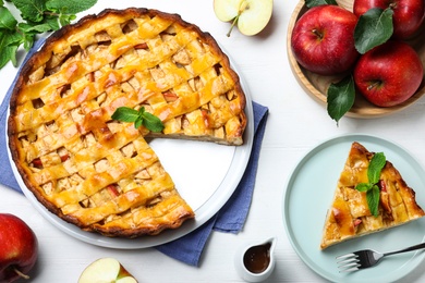Traditional apple pie and fresh fruits on white wooden table, flat lay