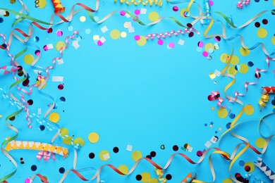 Frame made with carnival items on light blue background, flat lay. Space for text