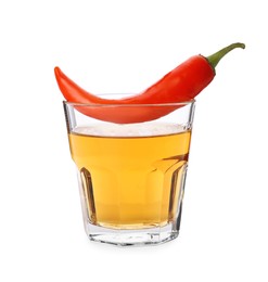 Red hot chili pepper and vodka in glass on white background