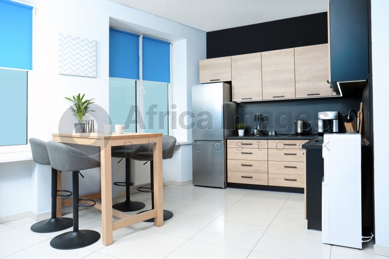 Photo of Cozy modern kitchen interior with new furniture and appliances
