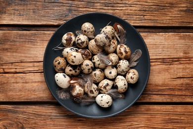 Plate with quail eggs on wooden table, top view