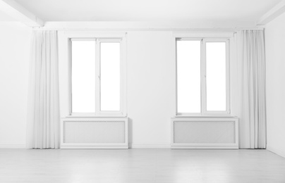 Windows with elegant curtains in empty room