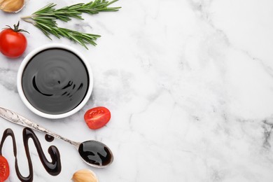 Photo of Organic balsamic vinegar and cooking ingredients on white marble table, flat lay. Space for text