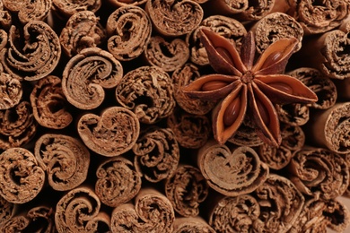 Aromatic cinnamon sticks and anise as background, top view