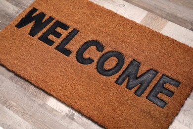 New clean mat with word WELCOME on floor, closeup