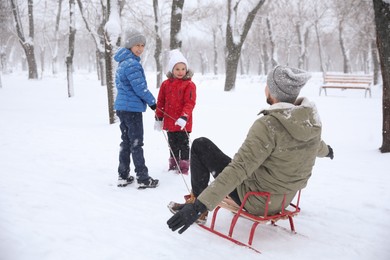 Father with his children spending time outside on winter day. Christmas vacation