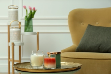 Burning candles in glass holders on table indoors, space for text. Interior elements
