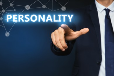 Man pointing at word PERSONALITY on virtual screen against dark blue background, closeup 