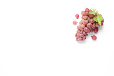 Bunch of ripe red grapes with green leaves on white background, top view