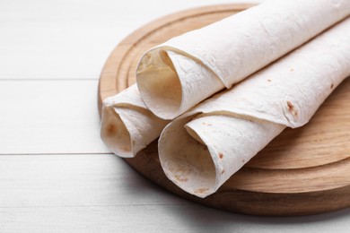 Photo of Delicious rolled Armenian lavash on white wooden table, closeup