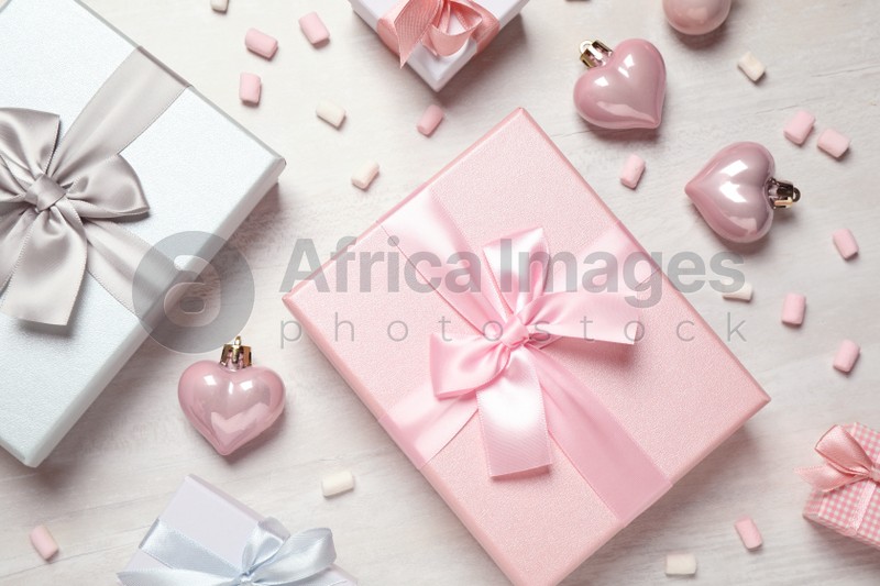 Beautiful gift boxes and festive decor on white table, flat lay