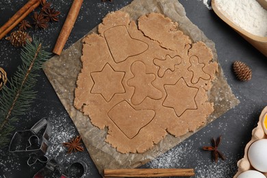 Photo of Making Christmas cookies. Flat lay composition with raw dough and ingredients on black table