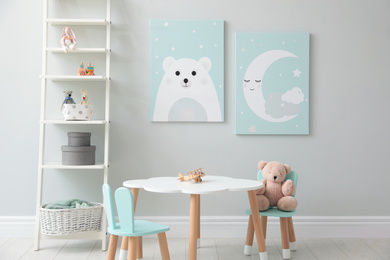 Children's room interior with table and cute pictures on wall