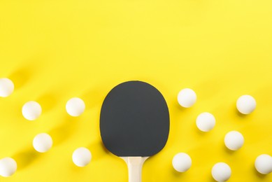 Ping pong racket and balls on yellow background, flat lay. Space for text