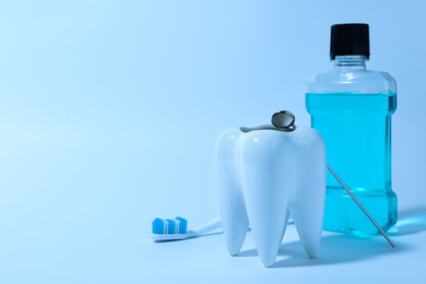 Composition with tooth shaped holder, mouthwash, brush and mirror on color background, space for text. Dentist consultation