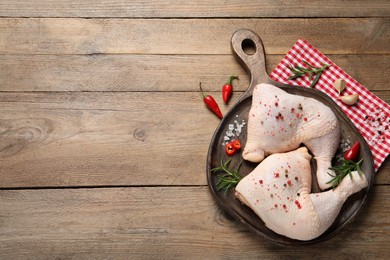 Raw chicken leg quarters and ingredients on wooden table, flat lay. Space for text
