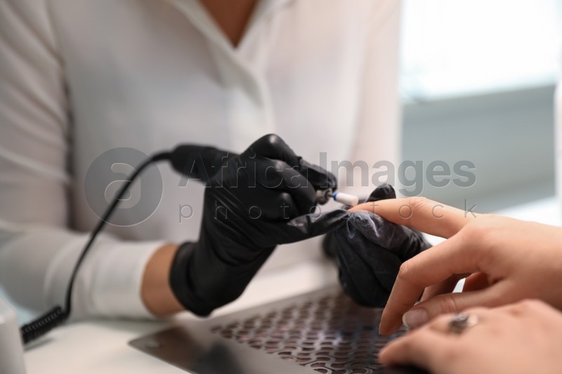 Professional nail artist working with client indoors, closeup