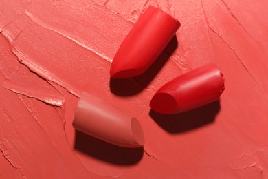 Different beautiful lipsticks as background, top view