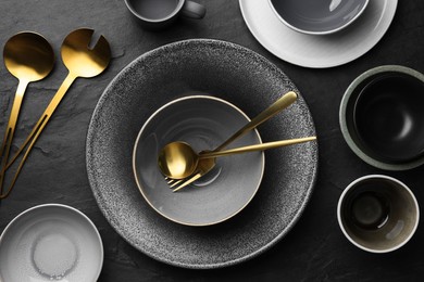 Photo of Set of clean tableware on black table, flat lay