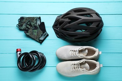 Flat lay composition with different cycling accessories on turquoise wooden background