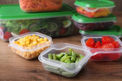 Set of plastic containers with fresh food on wooden  table