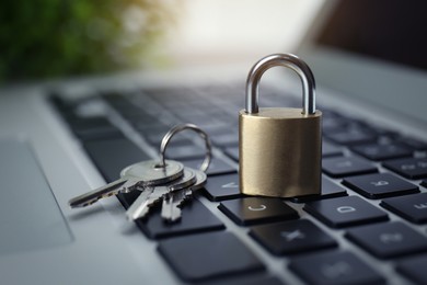 Metal padlock and keys on laptop keyboard, closeup. Cyber security concept
