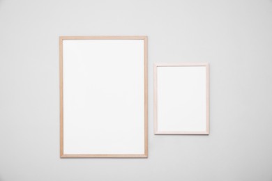 Photo of Empty frames on grey wall. Mockup for design