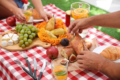 Photo of Couple with tasty food imitating picnic at home, closeup