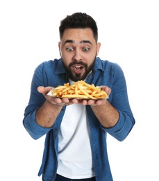 Hungry young man with French fries on white background