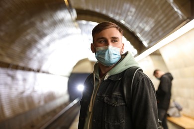 Young man in protective mask at subway station. Public transport