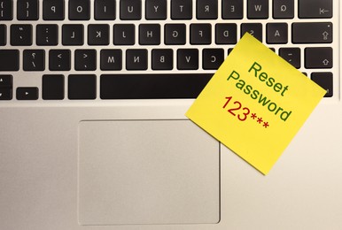 Sticky note with phrase Reset Password on laptop, top view