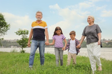 Cute children with grandparents walking in park
