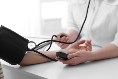 Photo of Doctor checking blood pressure of woman in clinic, closeup