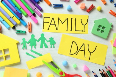 Cards with text Family Day surrounded by different stationery on white table, flat lay